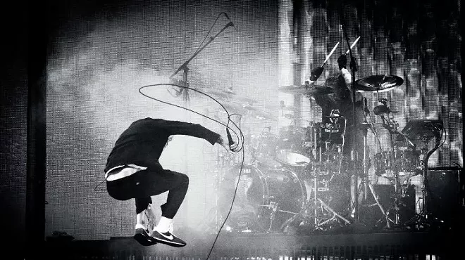 member of Deftones jumping on stage with a microphone