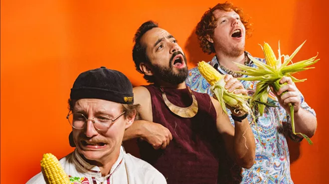 three men holding corn