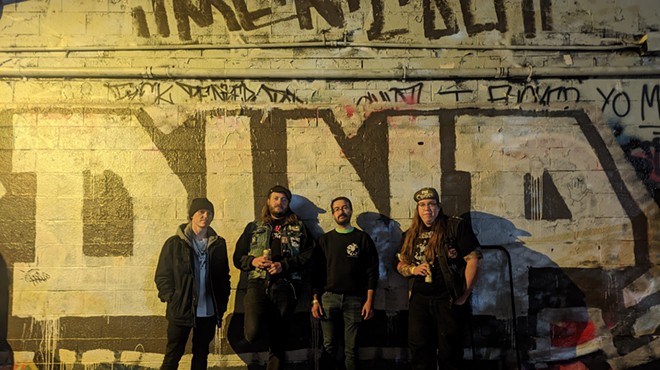a punk band in front of graffiti