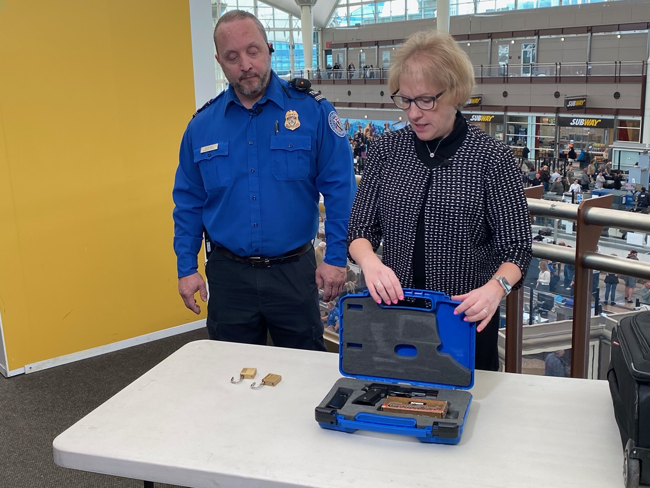 Supervisory TSA Officer Richard Mendoza and spokesperson Lorie Dankers show the proper way to store firearms while traveling.