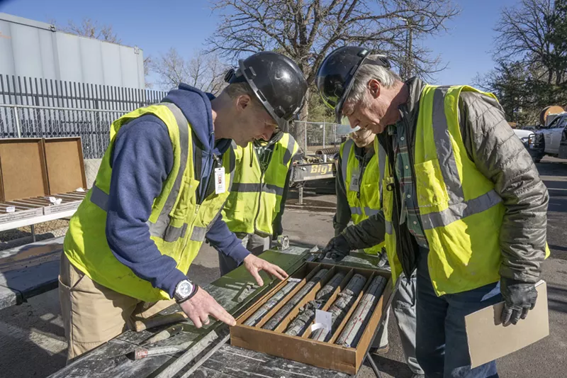 Image: People in yellow vests examine specimen