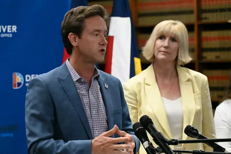 Image: Two people stand at a lectern.