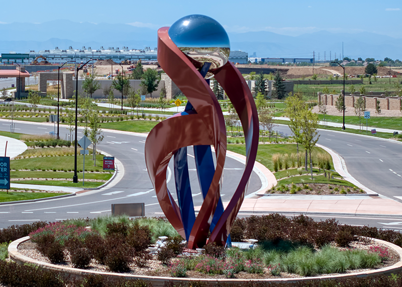 Image: an abstract sculpture between two streets