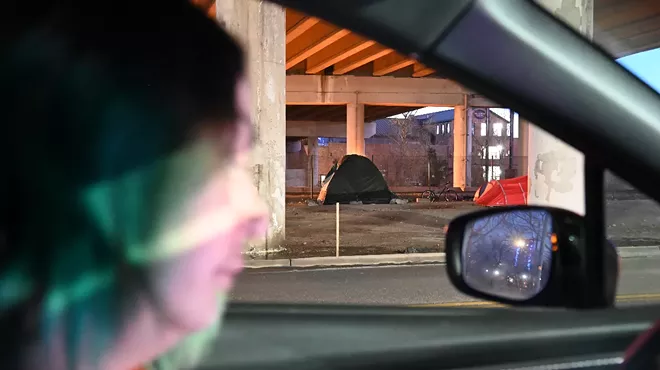 The Point in Time volunteer tallies a homeless person's tent.