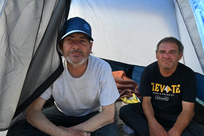 Randall McAda and Michael Dixon sit in their tent near 8th Avenue and Navajo Street. Both men hope Denver Mayor Mike Johnston will offer them housing after a planned sweep next week.