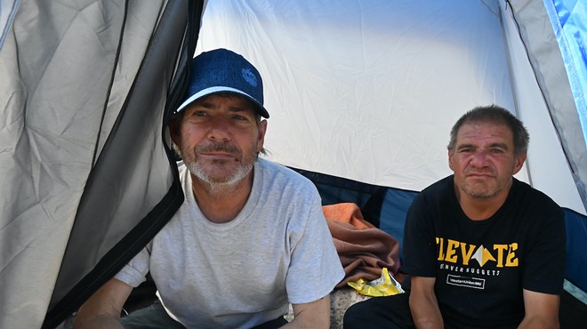 Two homeless residents sit in their tent in Denver.