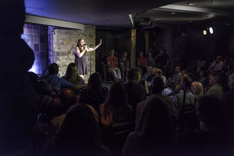 Image: woman doing standup at a comedy club