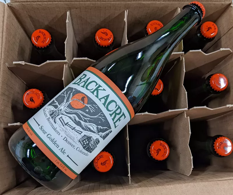 Image: Bottle of beer resting on a case of beer.