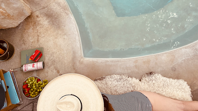 woman in hat lounging by a swimming pool