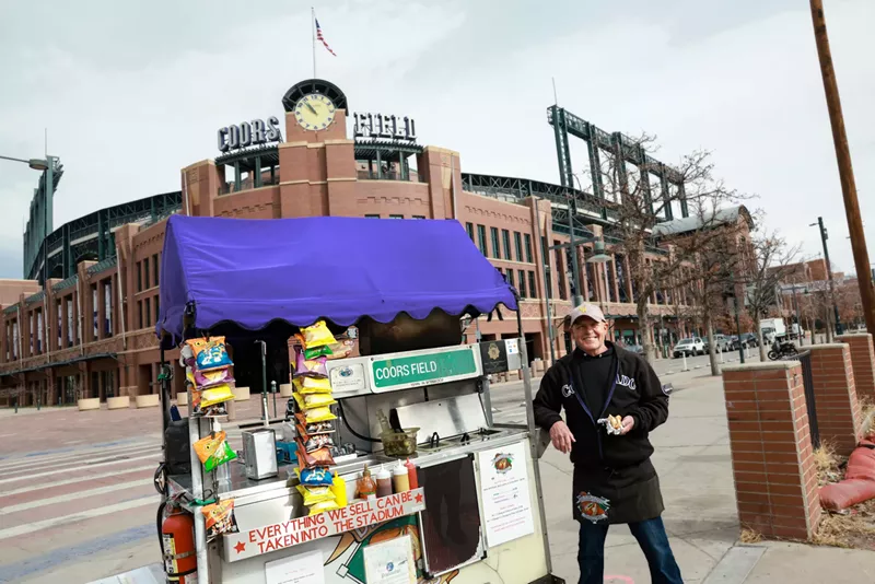 Image: man standing next to a hot dog cart