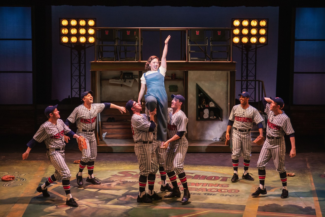 Jenna Moll Reyes, who plays Gloria the reporter, is lifted by baseball players during the musical number "Shoeless Joe from Hannibal, Mo."