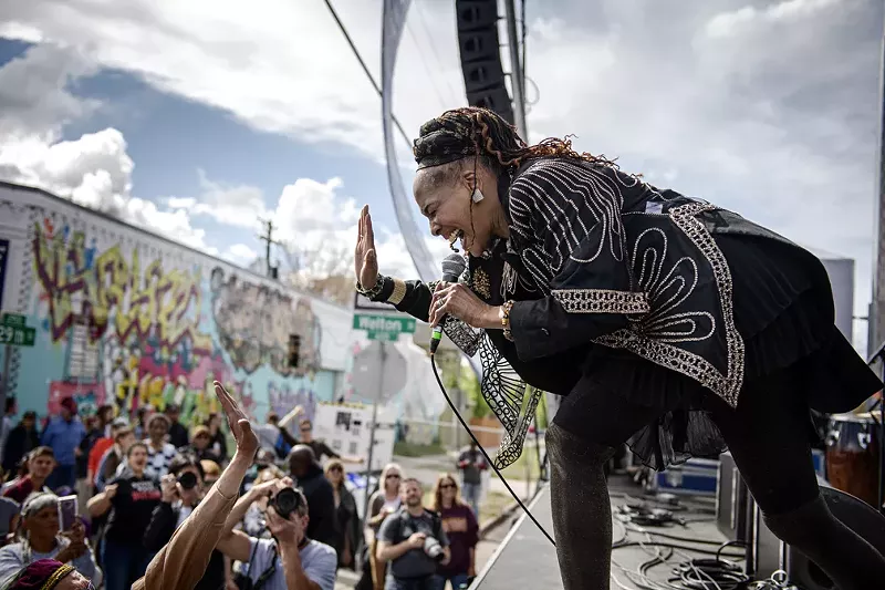 Image: woman singing on a stage to a crowd