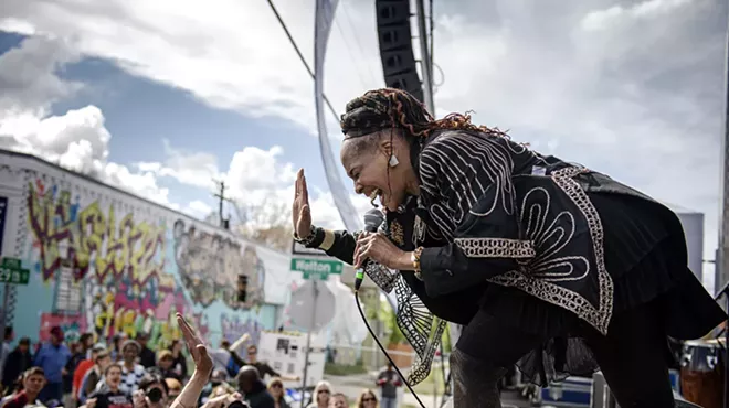 woman singing on a stage to a crowd