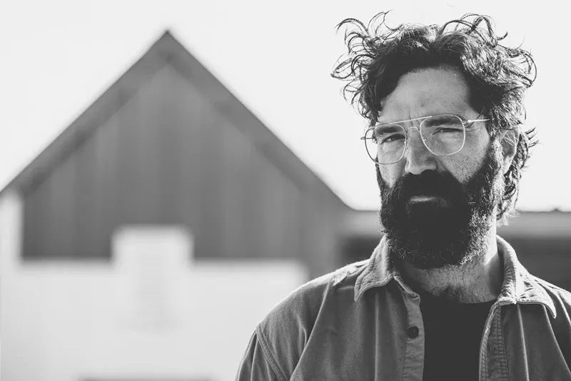 Image: man with glasses outside a pyramid