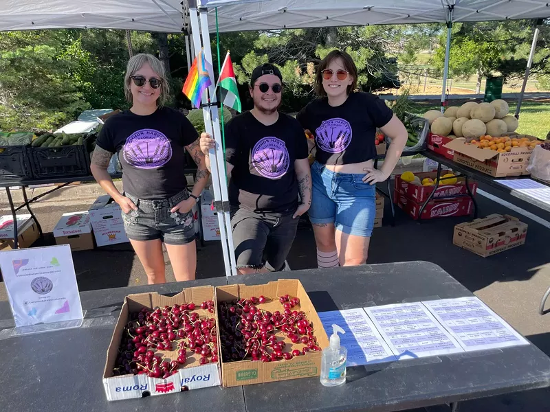 Image: The three Common Harvest Colorado co-founders underneath a tent at a farmers market