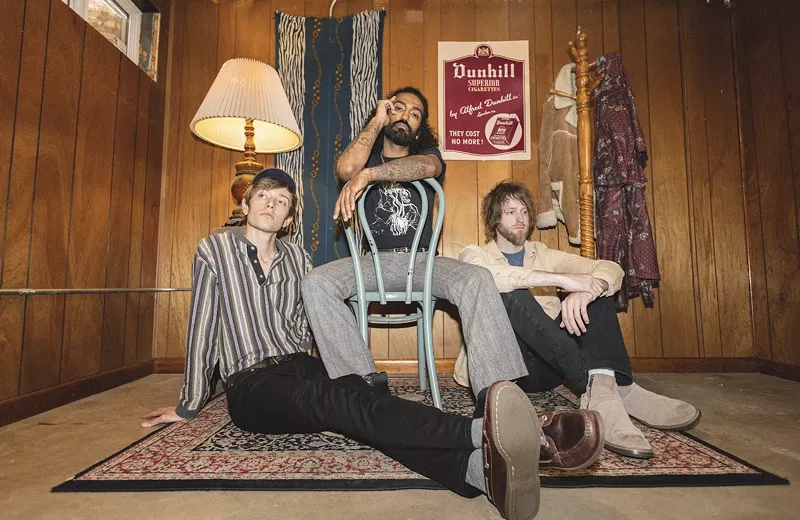 Image: bandmates pose in a yellow room on vintage furniture
