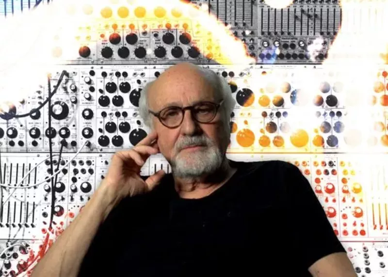 Image: a white man with a beard and glasses in a black shirt