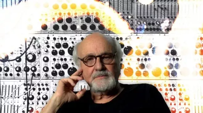 a white man with a beard and glasses in a black shirt