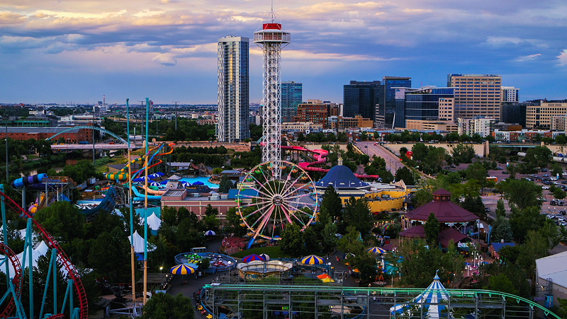Image: amusement park with Denver skyline.