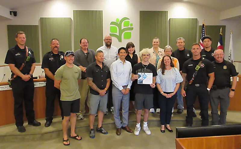 Image: Teenager poses with city councilmembers, police and firefighters