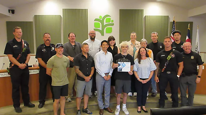 Teenager poses with city councilmembers, police and firefighters