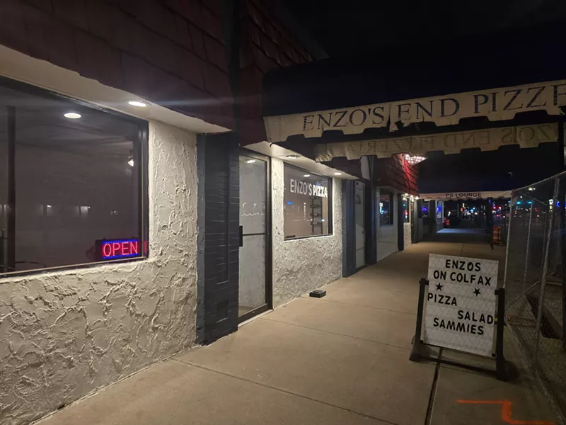 Image: Enzo's on Colfax storefront next to fence from the BRT construction.