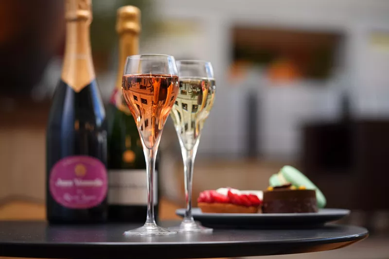 Image: two glasses of champagne and pastries