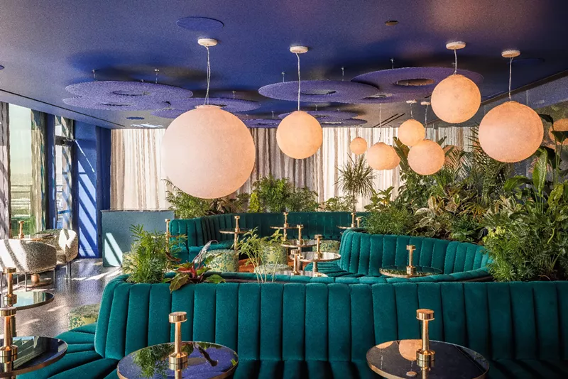 Image: teal couches in a room with large round lights