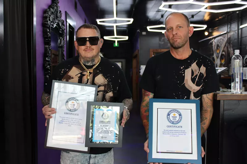 Image: Two men hold plaques.