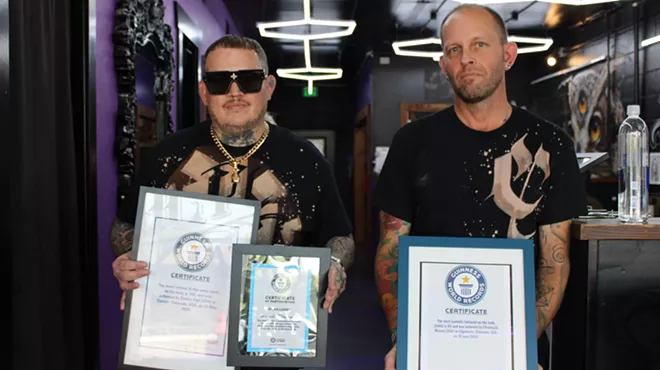Two men hold plaques.