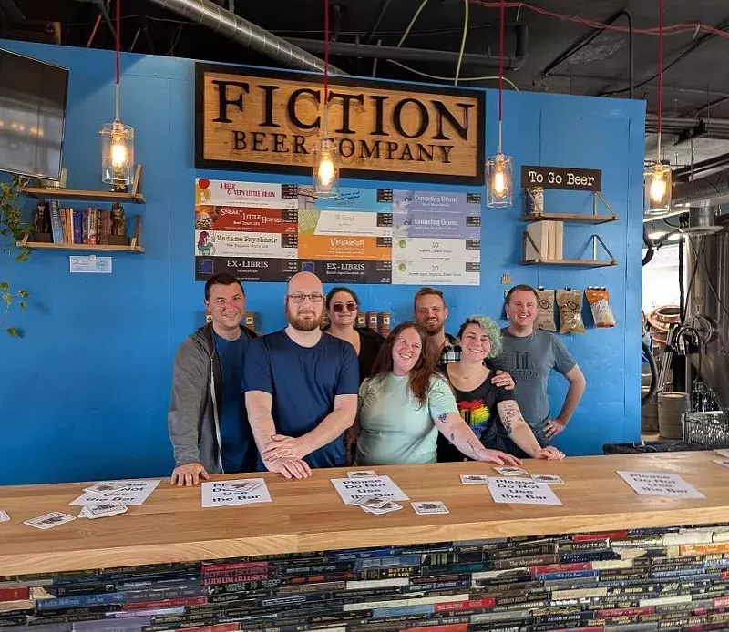 Image: Owners standing behind bar of brewery.