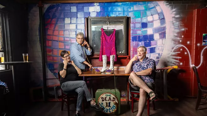 People sit in front of a disco ball mural