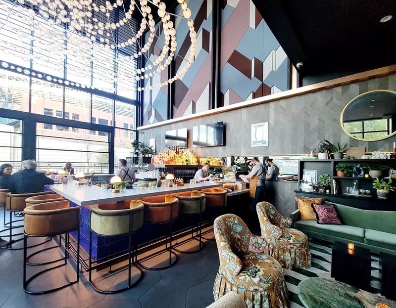 Image: sunlit bar with leather chairs and people sitting
