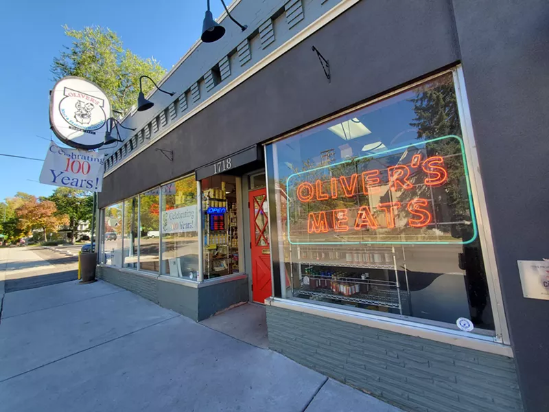Image: exterior of a shop with a neon sign in the window