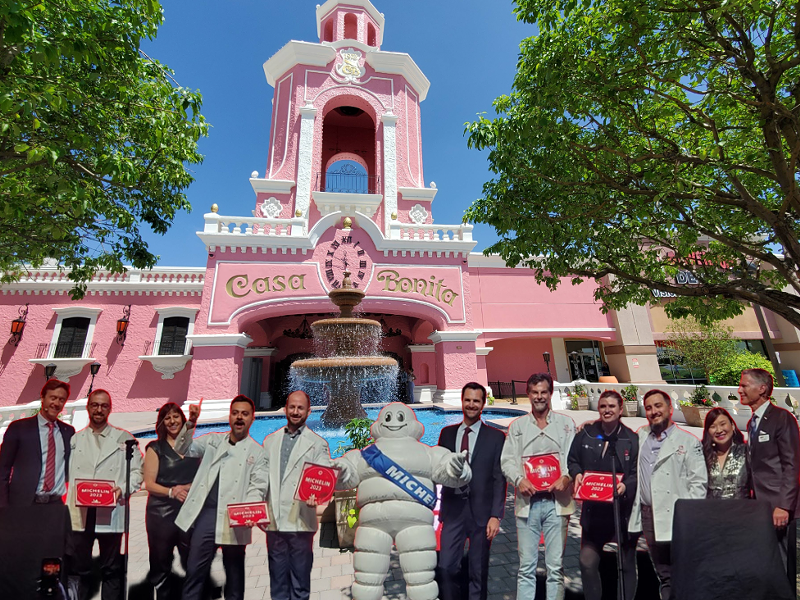 Image: photoshopped group of people in front of a pink building