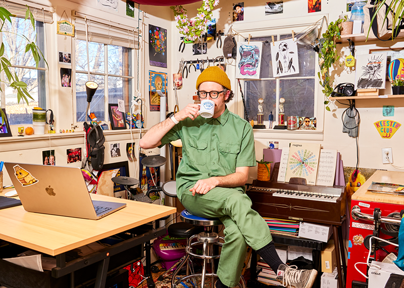Image: artist sitting in a studio drinking coffee