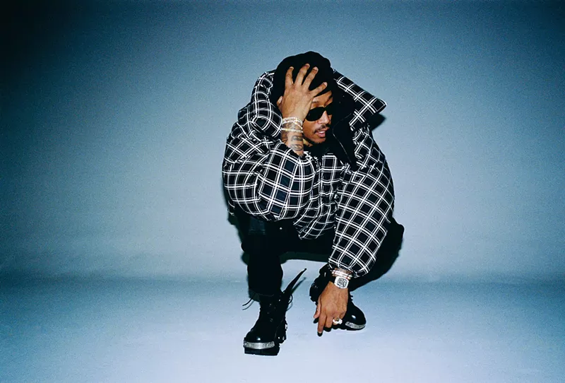 Image: man crouched holding his head