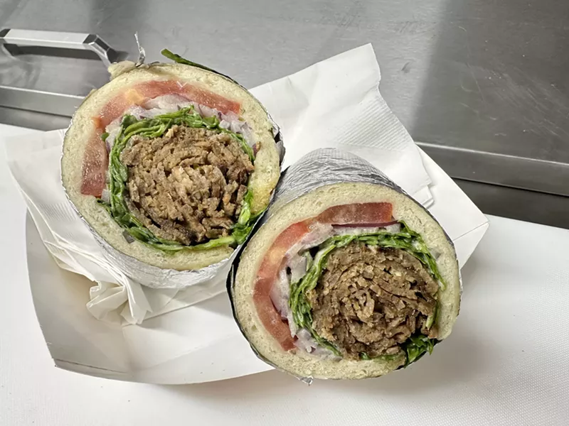 Image: a beef and lamb gyro wrapped in pita with tomatoes and arugula