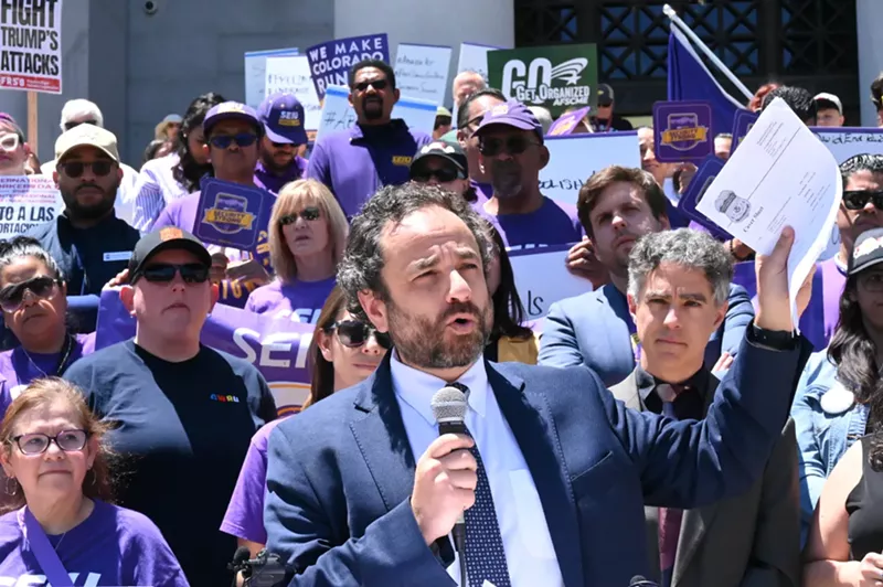 Image: A lawyer holds up papers.