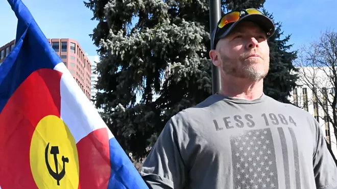 A man holds up a flag.