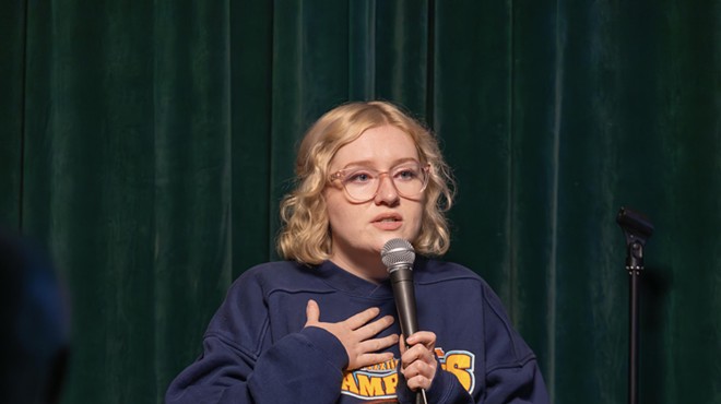 blonde woman with glasses at a microphone