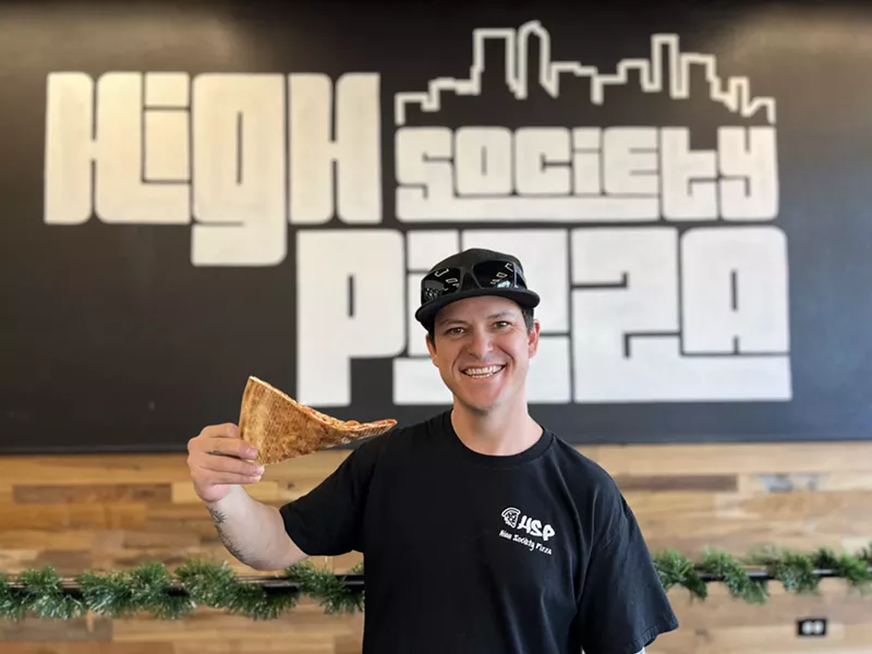 Image: man holding slice of pizza