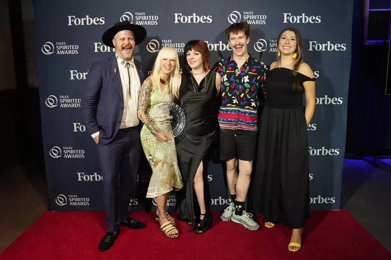 Image: a group of people posing on a red carpet