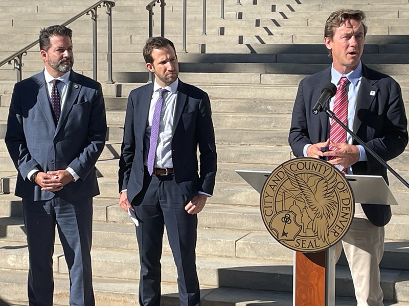 Mayor Mike Johnston speaks alongside Chad Maisel, a special assistant to the White House, and Jeff Olivet, the executive director of the U.S. Interagency Council on Homelessness.
