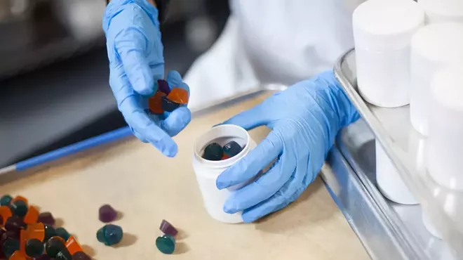 worker puts weed gummies in a bottle