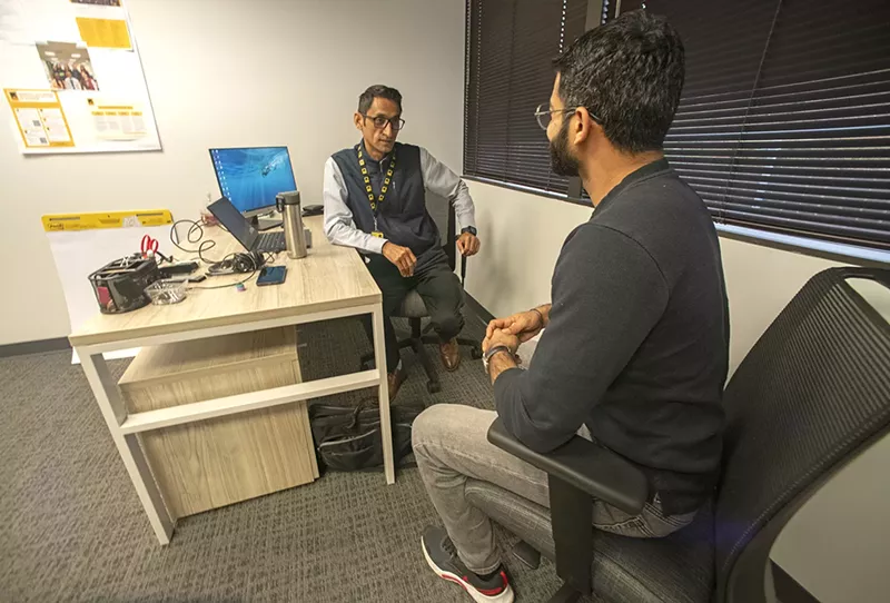 Image: A refugee speaks to another refugee.