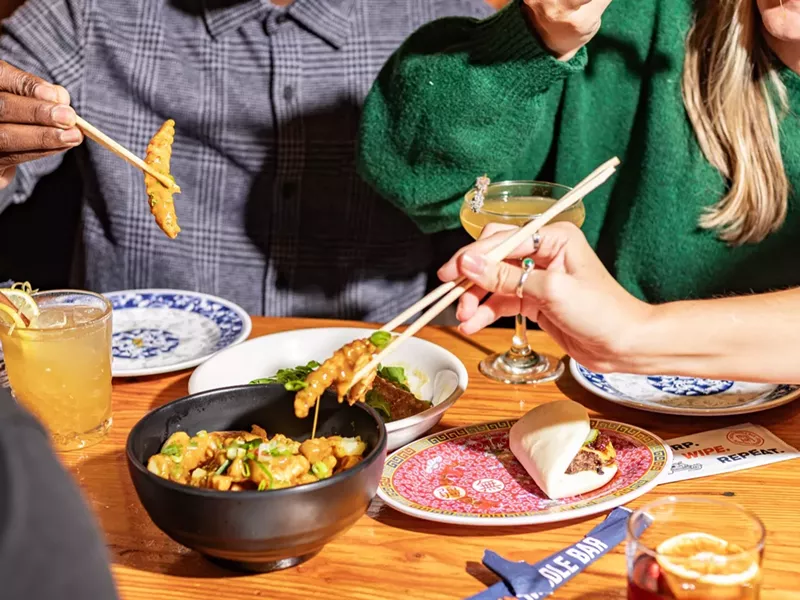 Image: various food on plates being eaten with chopsticks