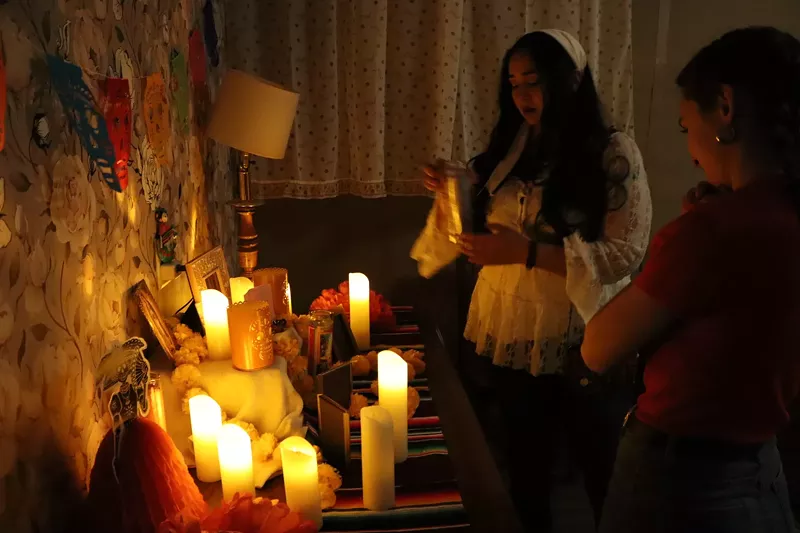 Image: A woman at an ofrenda.