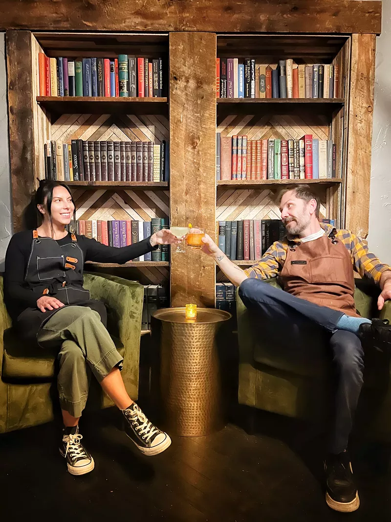 Image: two people sitting in chairs in front of a bookcase