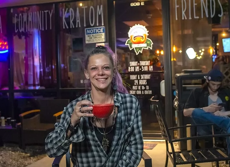 Image: woman with bowl of kava outside bar